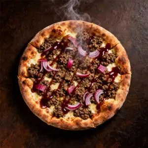 Overhead Scottish haggis pizza with sliced pickled red onions and whisky BBQ sauce on a dark background.